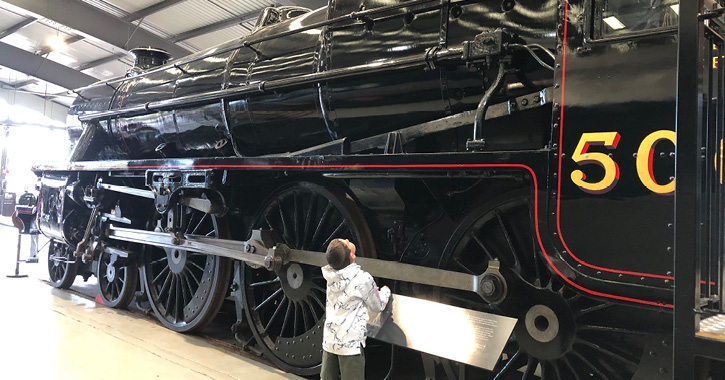 little boy looking at Black 5 5000 Engine inside Locomotion museum